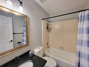 Full bathroom with shower / bath combo, toilet, and vanity