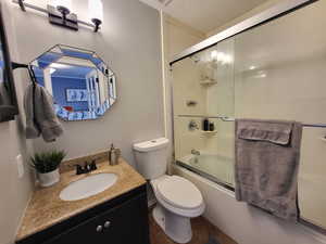 Master bathroom featuring shower / bath combination with glass door, vanity, and toilet