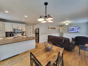 Dining room with a chandelier, light wood flooring, and sink