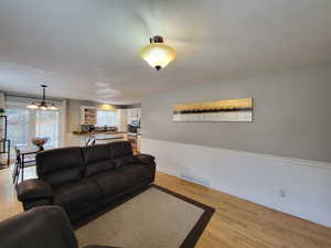 Living room featuring an inviting chandelier and light wood flooring