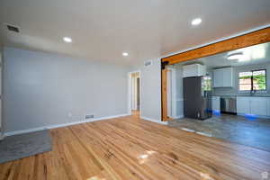 Unfurnished living room with light hardwood / wood-style floors and sink