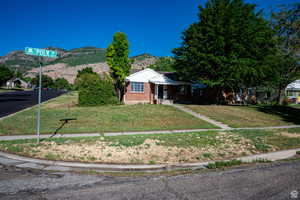 View of front of house featuring a mountain view and a front lawn