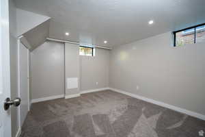 Basement with carpet and a textured ceiling