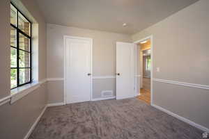 Unfurnished bedroom featuring light carpet