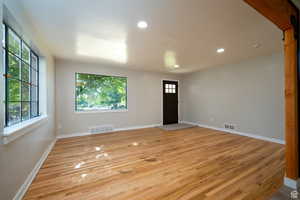 Spare room featuring plenty of natural light and light wood-type flooring