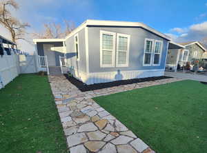 Rear view of property featuring a lawn and a carport