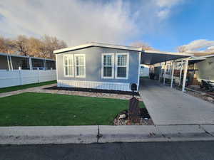 View of front of property with a front yard and a carport