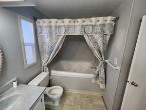 Bathroom with plenty of natural light, toilet, a tub to relax in, and vanity