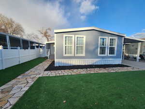 View of property exterior with a lawn and a carport