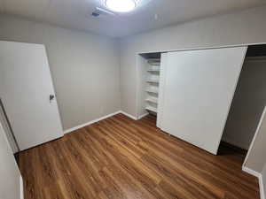 Unfurnished bedroom featuring hardwood / wood-style floors and a closet