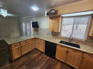 Kitchen featuring kitchen peninsula, light stone counters, sink, dishwasher, and dark hardwood / wood-style floors