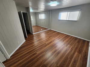 Unfurnished bedroom with multiple windows and dark wood-type flooring