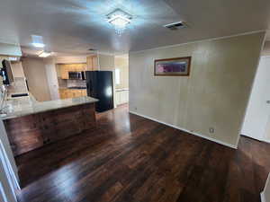 Kitchen featuring sink, dark hardwood / wood-style floors, light stone countertops, appliances with stainless steel finishes, and kitchen peninsula