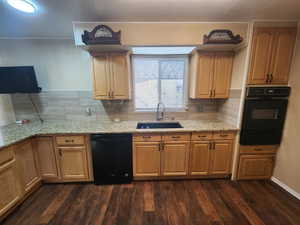 Kitchen with dark hardwood / wood-style flooring, decorative backsplash, sink, and black appliances