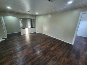 Unfurnished room featuring dark hardwood / wood-style flooring and a textured ceiling