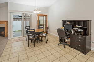 Tiled dining room featuring a tiled fireplace and an inviting chandelier