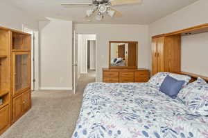 Carpeted bedroom featuring ceiling fan