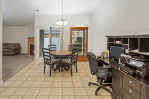 Dining space featuring light carpet and a notable chandelier