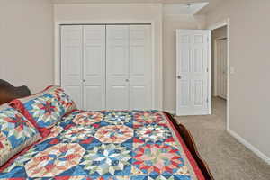 Bedroom featuring light carpet and a closet