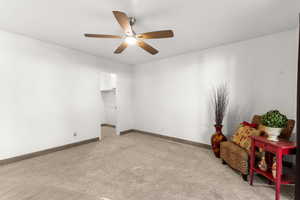 Carpeted spare room featuring ceiling fan