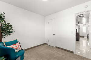 Living area with ceiling fan and light carpet