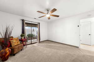 Interior space with light carpet and ceiling fan