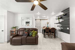 Living room featuring a barn door and ceiling fan