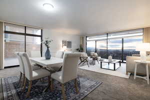 Dining space with carpet flooring and expansive windows