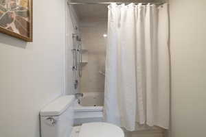 Bathroom with shower / tub combo and toilet