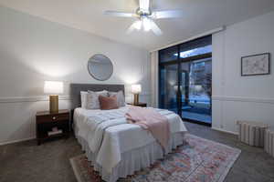 Carpeted bedroom featuring ceiling fan and access to exterior