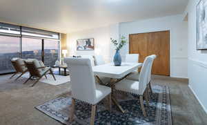 Dining area with carpet and a wall of windows