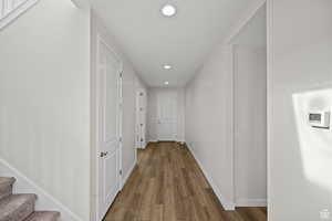 Hallway with hardwood / wood-style floors