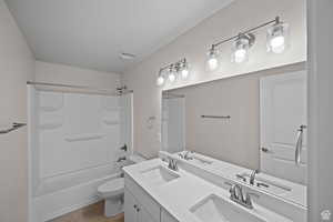 Full bathroom featuring tile patterned floors, vanity, toilet, and shower / tub combination