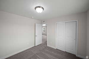 Unfurnished bedroom featuring carpet flooring and a closet