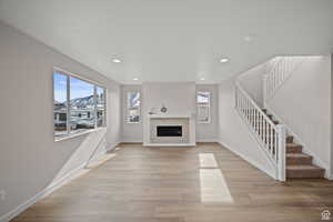 Unfurnished living room with a mountain view and light wood-type flooring