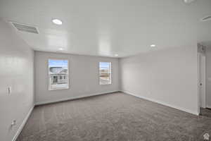 Carpeted spare room featuring a textured ceiling