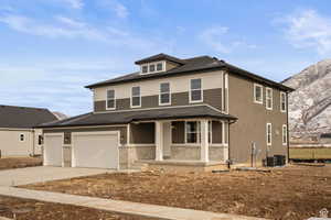 View of front of home with cooling unit, a porch, and a garage