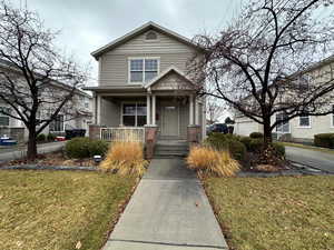 View of front facade featuring covered porch and a front yard