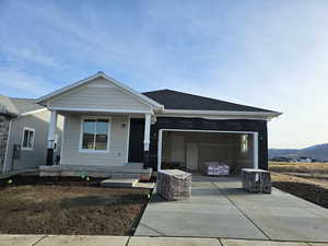 View of front of home featuring brick, a porch, and a garage