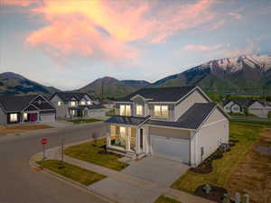 View of front of home with a mountain view, cooling unit, a porch, and a garage