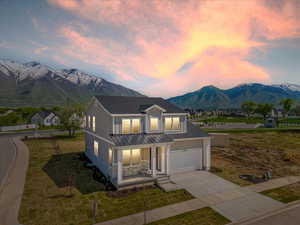 View of front of home with a mountain view, a garage, and covered porch