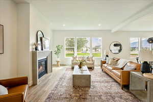 Living room with beam ceiling and light hardwood / wood-style flooring