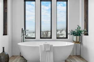 Bathroom with a washtub and wood-type flooring