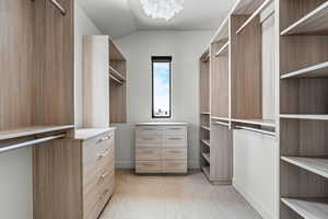 Spacious closet featuring lofted ceiling and a chandelier