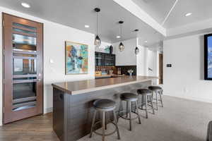 Kitchen featuring a breakfast bar, kitchen peninsula, backsplash, and decorative light fixtures