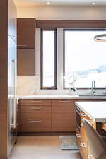 Kitchen featuring decorative backsplash, light hardwood / wood-style flooring, a healthy amount of sunlight, and sink