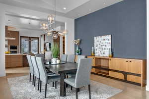 Dining room with light hardwood / wood-style flooring and lofted ceiling