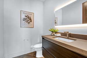 Bathroom with vanity, wood-type flooring, and toilet