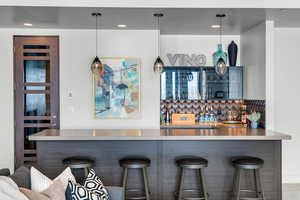 Interior space featuring tasteful backsplash, sink, and pendant lighting