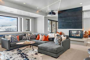 Living room featuring a multi sided fireplace and light colored carpet